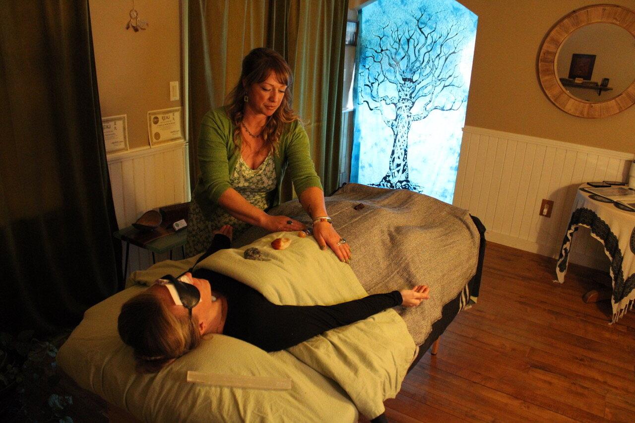 Camilla Norsworthy giving a Reiki session on the heated table at Awaken Reiki Studio in Dover-Foxcroft, Maine