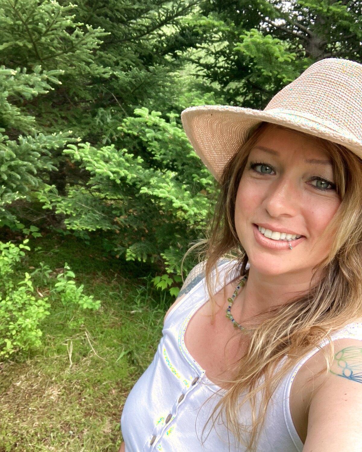 Camilla Norsworthy outdoors among the evergreens in the Maine woods