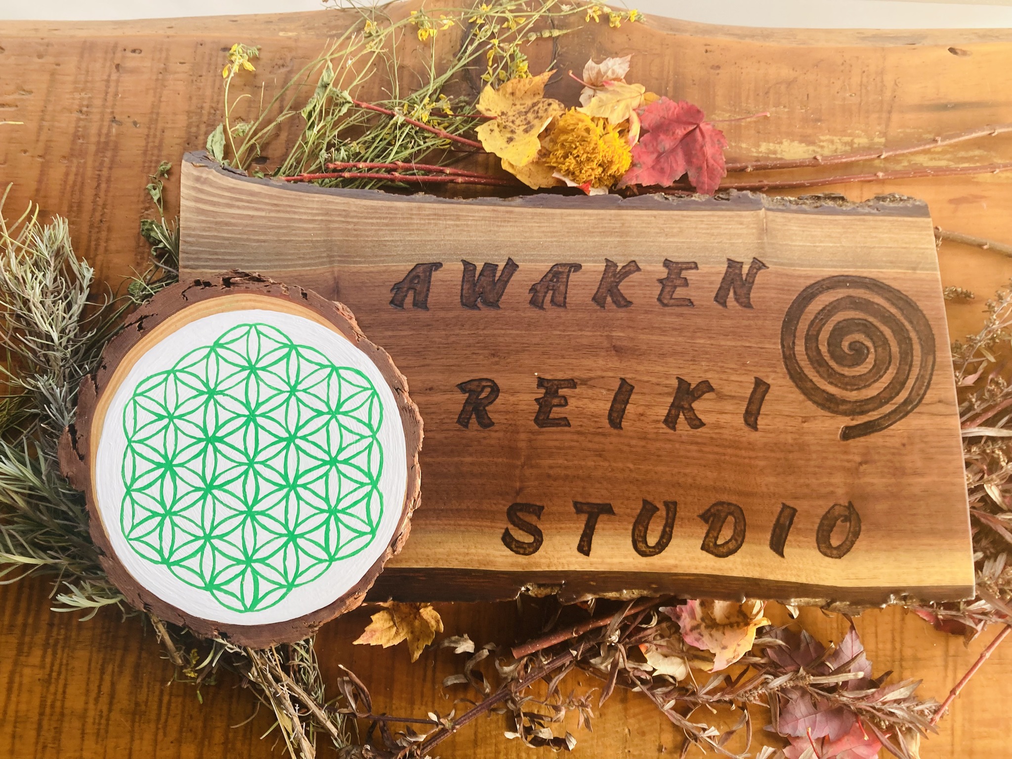 Awaken Reiki Studio hand-carved wooden sign with Flower of Life sacred geometry symbol